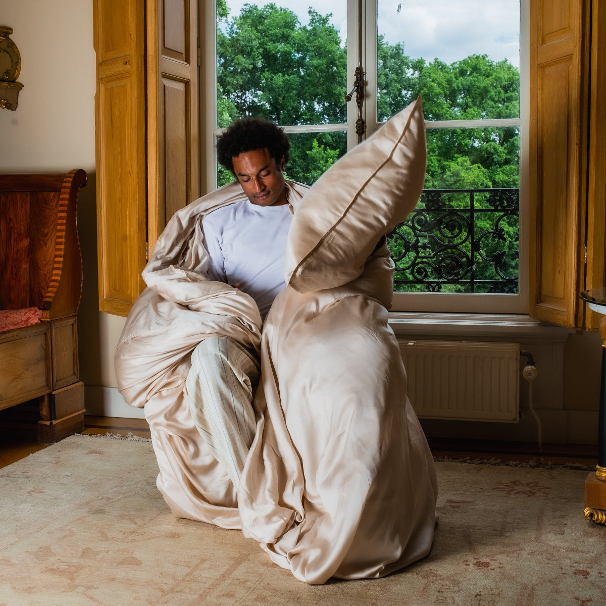 Jongen met op een stoel met een Wocha dekbedovertrekset van tencel in oat kleur