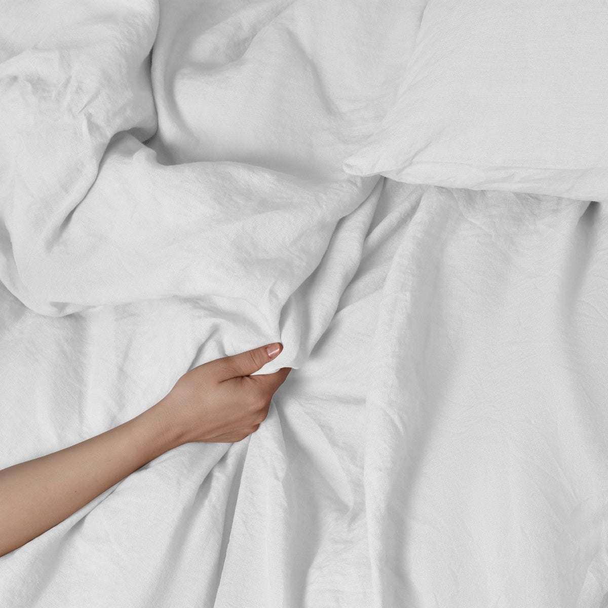 Een hand die een wocha dekbedovertrekset voelt van gewassen linnen