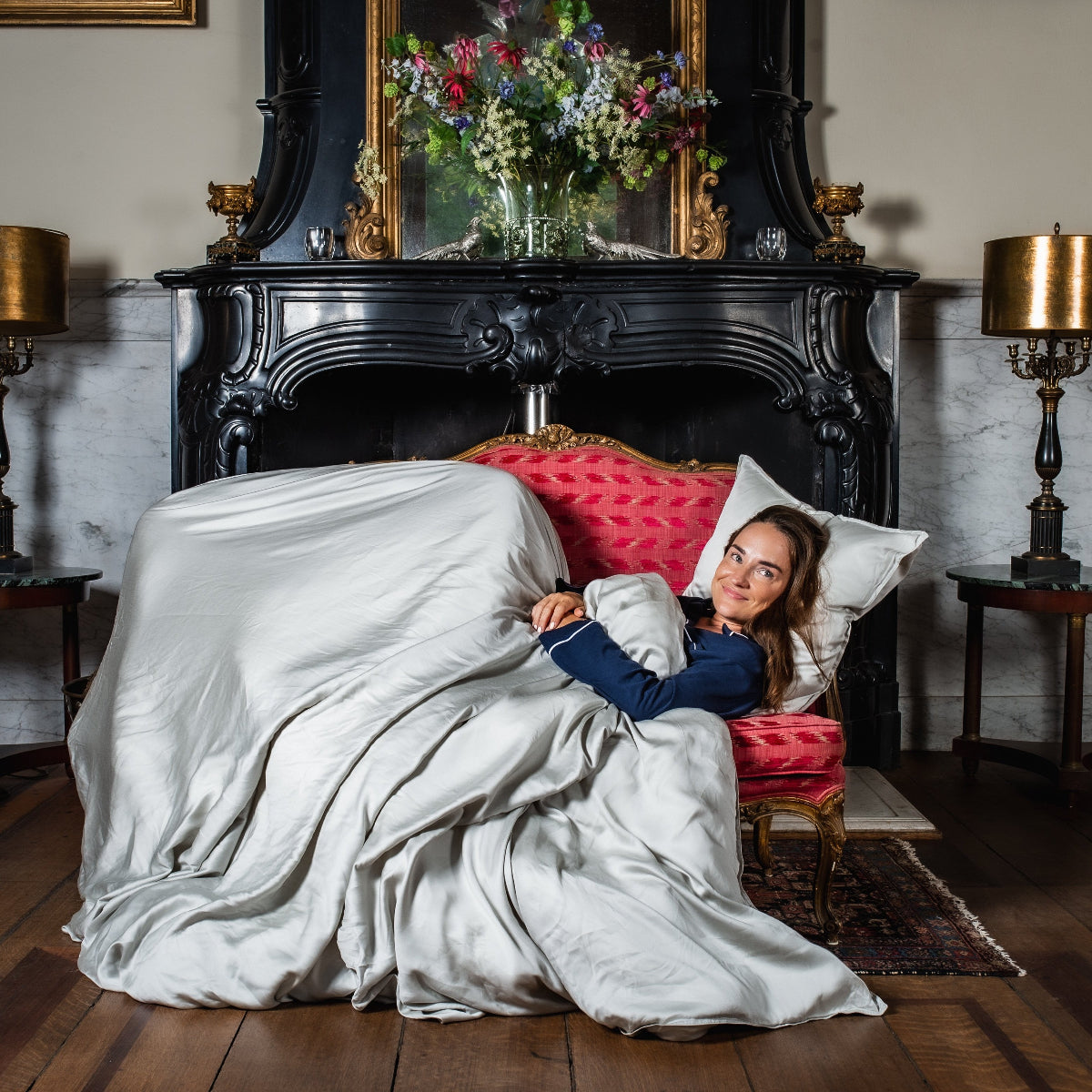 Vrouw liggend op een bankje met luxe grijs tencel dekbedovertrekset van Wocha 